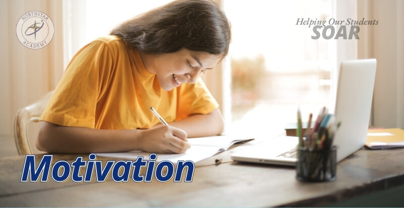 A student smiles as she does work homework at a desk